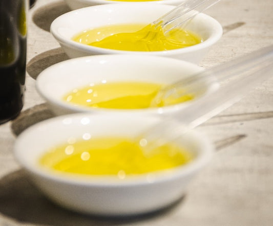 Three bowls contained organic Greek olive oil samples and transparent plastic spoons